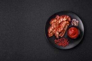 delicioso fresco frito bacon com sal e especiarias em uma Sombrio fundo foto