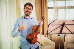 homem jogando violino às lar. ele é limpeza dele instrumento. foto