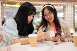 dois feliz jovem ásia fêmea amigos estão suspensão Fora juntos às a compras Shopping em a fim de semana. foto