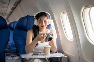 uma fêmea passageiro é verificação As fotos em dela Câmera durante a voar do dela verão período de férias.