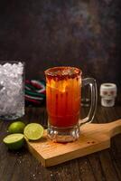 Michelada, típica mexicano coquetel em uma de madeira mesa. coquetel Sediada em cerveja. foto