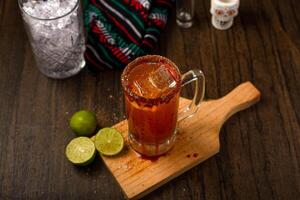 Michelada, típica mexicano coquetel em uma de madeira mesa. coquetel Sediada em cerveja. foto