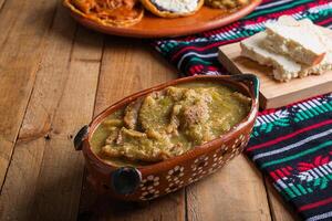 chicharrones dentro verde molho, típica mexicano Comida. mexicano Comida dentro argila Panela. foto