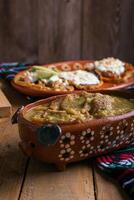 chicharrones dentro verde molho, típica mexicano Comida. mexicano Comida dentro argila Panela. foto
