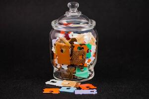 uma vidro jarra preenchidas com grande quantidade do multicolorido plástico pão Tag foto