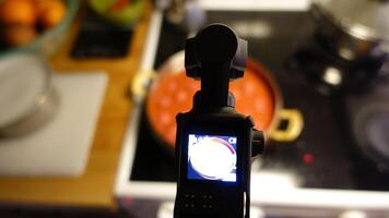 uma digital Câmera é filmando caseiro almôndegas fervendo dentro tomate molho foto