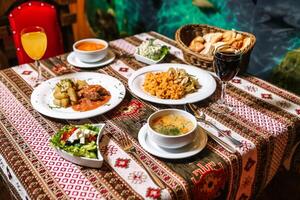 mesa com pratos do Comida e taças do sopa foto