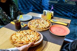 dois pizzas em de madeira mesa foto