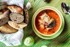 tigela do sopa e cesta do pão em mesa foto