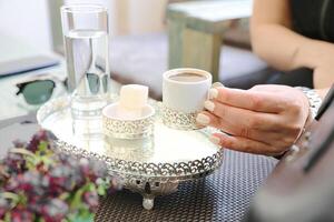 mulher segurando uma café copo em mesa foto