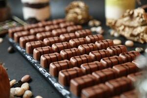 abundante sortimento do chocolates e nozes em mesa foto