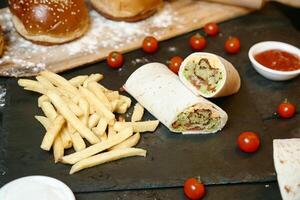 apetitoso sanduíche e francês fritas em mesa foto