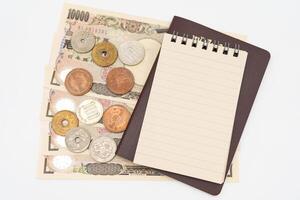 em branco papel bloco de anotações e tailandês Passaporte com japonês dinheiro. férias, planejamento orçamento. viagem plano conceito. foto