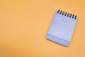 azul escrivaninha calendário para novembro 2024 isolado em laranja fundo. calendário conceito com cópia de espaço. plano deitar. foto