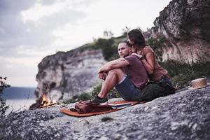 olhar pensativo. duas pessoas queridas acampam à noite no final de sua caminhada por bosques e montanhas foto