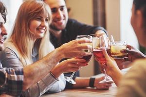 mãos de pessoas com copos de uísque ou vinho, celebrando e brindando em homenagem ao casamento ou outra celebração foto