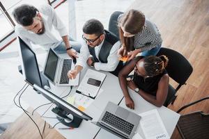 um grupo de pessoas multinacionais ocupadas trabalhando no escritório. foto