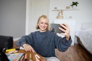 retrato do jovem mulher, menina beleza blogueiro, gravação vlog dentro dela quarto, fazendo Maquiagem tutorial para social meios de comunicação seguidores, levando selfies, viver transmissão em Móvel telefone aplicativo foto