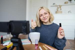 jovem carismático beleza blogueiro, Adolescência menina registros do dela aplicando rímel, revendo Maquiagem produtos para dela estilo de vida vlog, vlogging para social meios de comunicação conta foto