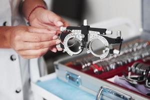 mudar as lentes. mãos femininas segurando o dispositivo óptico para teste de visão foto