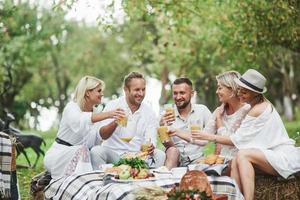 amigos adultos bebem suco de laranja e sorrindo. parte externa do restaurante foto