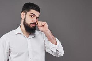 hipster com cara séria. sentimento e emoções. cara ou barbudo em fundo cinza. moda e beleza do barbeiro. homem com barba comprida e bigode, copie o espaço foto