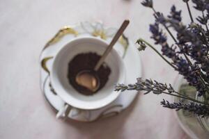 uma copo do café com canela e lavanda flor em uma mesa. foto