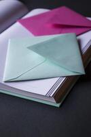a turquesa e Rosa cores envelopes em a aberto bloco de anotações, fechar acima. foto