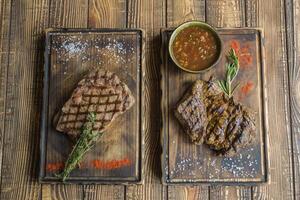 grelhado carne com especiarias e molho em uma de madeira mesa. foto
