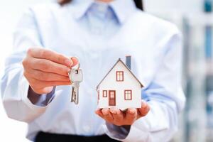 Estado agente ofertas casa chaves e modelo lar, ilustrando bem sucedido propriedade. foto