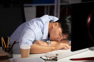 homem de negocios trabalhando hora extra às dele escritório ele sentido cansado. foto