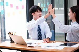 bem sucedido o negócio equipe a comemorar dentro escritório foto