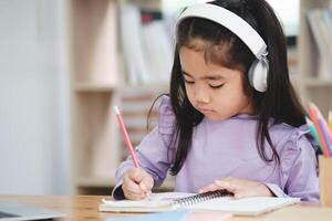 uma jovem menina é sentado às uma escrivaninha com uma lápis e uma caderno foto