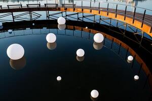 moderno Projeto do a lazer parque em a água, minimalismo do branco bolas em a superfície do a lago, uma cidade lago, a arte objeto dentro natureza, uma Projeto solução para a panorama. foto