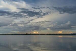 tormentoso tarde céu sobre lago foto