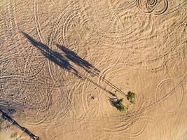 pegadas, faixas e sombras em areia foto