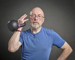 Senior homem exercício com ferro kettlebell foto