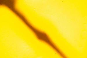 uma sombra diagonal fina na velha tinta amarela desbotada que é coberta com metal. fundo abstrato. foto