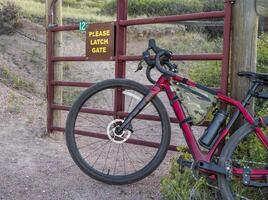 cascalho bicicleta às uma gado portão em uma trilha foto