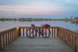 cascalho excursão bicicleta às uma lago costa às crepúsculo foto