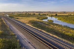 rodovia e Ferrovia através Nebraska montes de areia ao longo a meio lupo rio, aéreo Visão foto