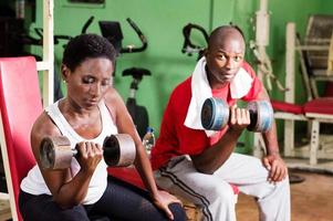 jovem e treinador fazem musculação em um ginásio. foto