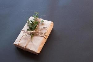 caixa de presente artesanal com nó natural com folhas verdes sobre fundo preto