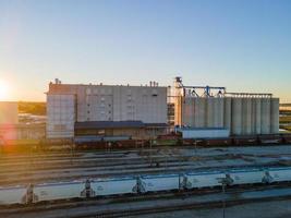 pátio ferroviário tranquilo ao pôr do sol com contêineres de carga esperando foto