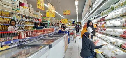 cliente escolhendo vários mercearias produtos dentro mercearia loja. supermercado conceito. bekasi, oeste Java, Indonésia - marcha 8 2024 foto