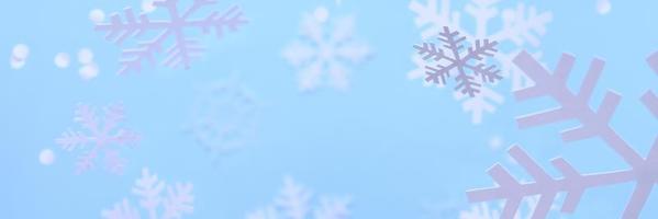 fundo de inverno. flocos de neve brancos cortados de um papel branco sobre um fundo azul. foto