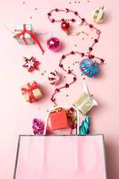 pacote com decoração de Natal diferente em fundo rosa. conceito de ano novo. foto
