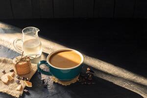 café dentro uma verde copo com fresco leite e café da manhã pão em uma Preto de madeira mesa dentro uma café fazer compras com uma fundo do caloroso natural claro. foto