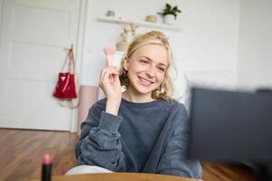 retrato do conteúdo meios de comunicação O Criador, blogueiro senta dentro dela quarto e registros do dela favorito Maquiagem escovas, fala em Câmera foto