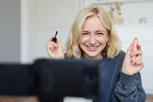 retrato do beleza blogueiro, mulher registros em Câmera dentro dela sala, mostra Maquiagem beleza produtos, fala sobre cosméticos dentro vlog, faz estilo de vida conteúdo para seguidores em social meios de comunicação foto